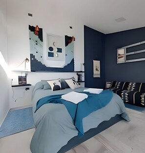 A modern bedroom with a bed, bedside tables, and a wall-mounted artwork. - Okeyloft 2 Coyhaique (Coyhaique)