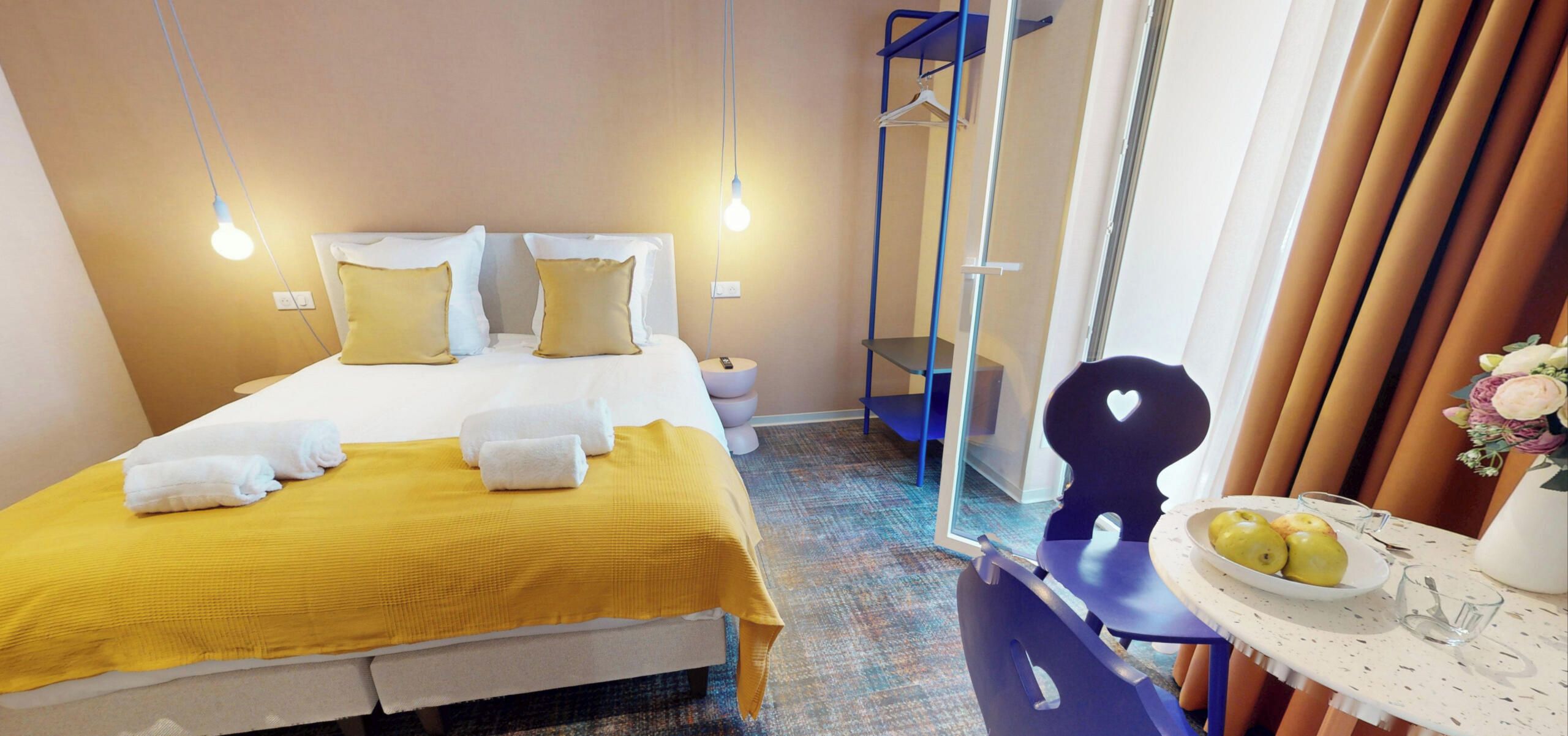 Ein Hotelzimmer mit Bett, Nachttisch und Stuhl.