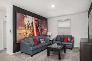 A living room with two grey sofas, a coffee table, and a large Star Wars-themed wall mural. - 3 Themed BRs - Heated Pool, Spa & Kids Playroom (Davenport)