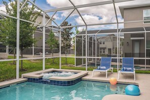 A pool area with a hot tub, lounge chairs, and a glass-enclosed structure. - 3 Themed BRs - Heated Pool, Spa & Kids Playroom (Davenport)
