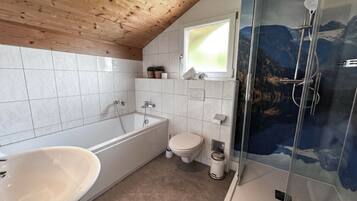 A bathroom with a bathtub, toilet, and shower.
