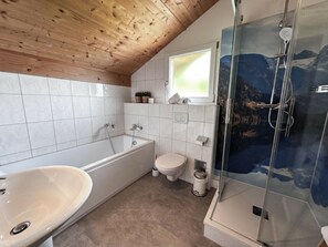A bathroom with a bathtub, toilet, and shower. - Cabin in Annaberg With Swimming Pool (Annaberg-Lungoetz)