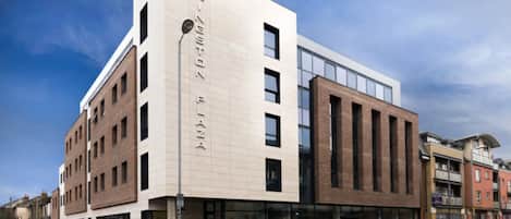 A modern building with a prominent sign, large windows, and a flat roof.