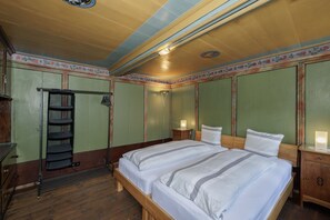 A room with two beds, a wardrobe, a shelf unit, and a radiator. - Chasa Plaz: Cozy 4.5-room vacation rental on the village square in Sent (Sent)