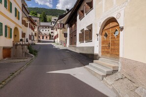 Un carrer estret flanquejat per edificis tradicionals amb portals arquejats i persianes de fusta.