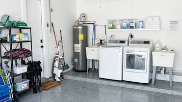 A laundry room with a ceiling fan, a water heater, and a washing machine.