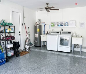 Une buanderie équipée d’un ventilateur de plafond, d’un chauffe-eau et d’un lave-linge.