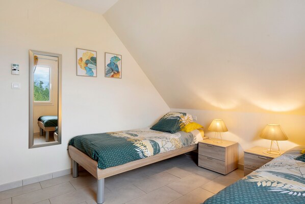 A bedroom with a bed, bedside tables, lamps, and a mirror.