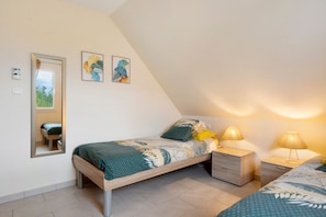 Une chambre à coucher avec un lit, des tables de chevet, des lampes et un miroir.