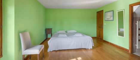 Un dormitorio con una cama, una silla y una puerta.