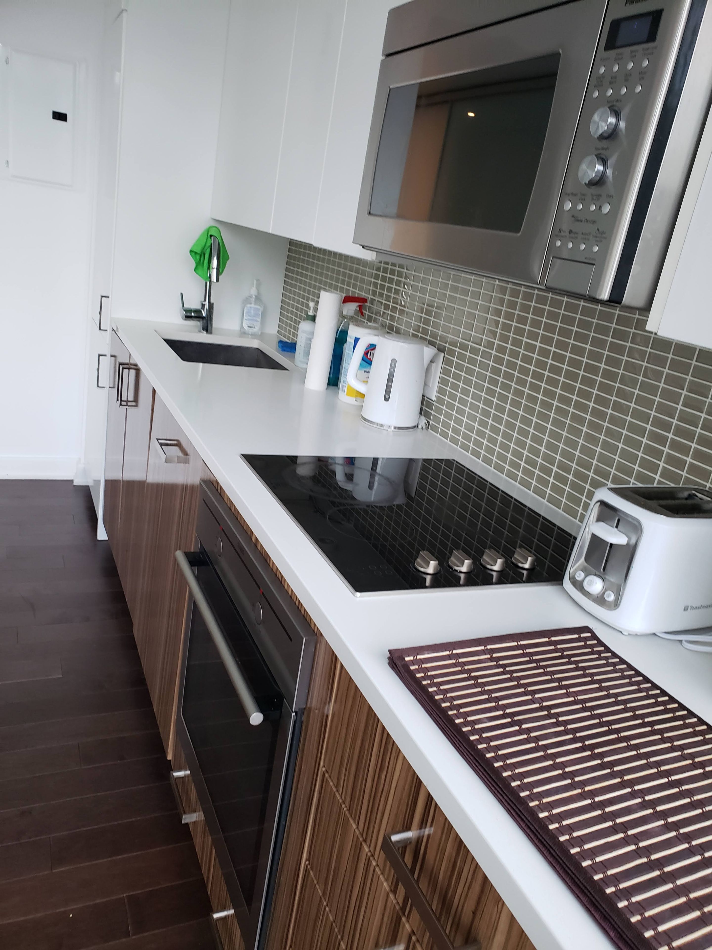 Une cuisine moderne équipée d’un four, d’un micro-ondes et d’un grille-pain encastrés.