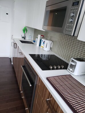 A modern kitchen with a built-in oven, microwave, and toaster.