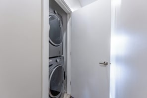 A closed door with a built-in washer and dryer unit. - The Fern & Fiddle by Stay Local Nashville - Skyline Views & Games Near Downtown (Nashville)