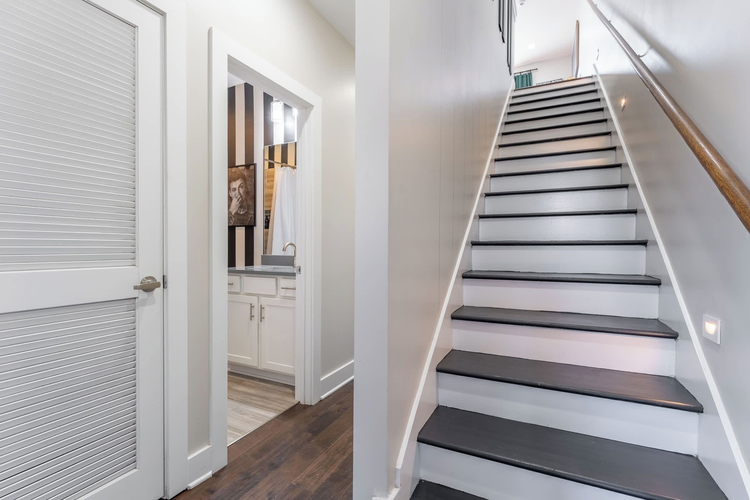 A staircase with a wooden handrail and white walls.