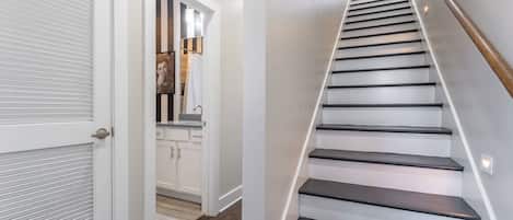 A staircase with a wooden handrail and white walls.
