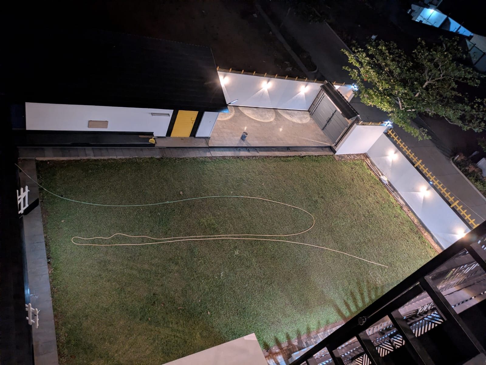 An aerial view of a building with a grassy courtyard, a pathway, and a person standing near the entrance.