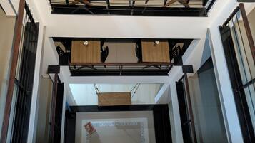 A modern interior with a central staircase, wooden paneling, and a decorative tile border.