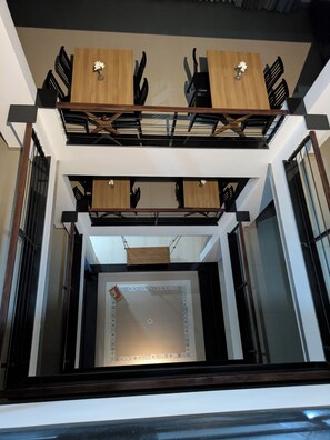A modern interior with a central staircase, wooden paneling, and a decorative tile border.