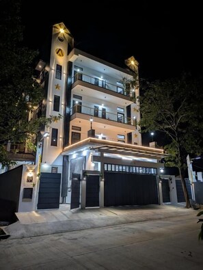 A multi-story building with a modern design, featuring balconies and a garage entrance. - Abhimaan (Mysore)