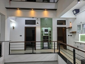 Ein modernes Interieur mit einer Treppe, einer Wand in Grünton und einem Küchenbereich.