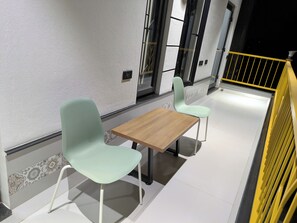 Ein helles, modernes Interieur mit zwei leichten Stühlen und einem Holztisch, das an einen ungezwungenen Essbereich erinnert.