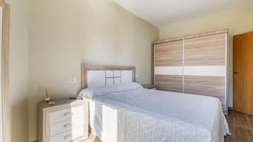 Una camera da letto con un letto, un comodino, una cassettiera e un armadio.