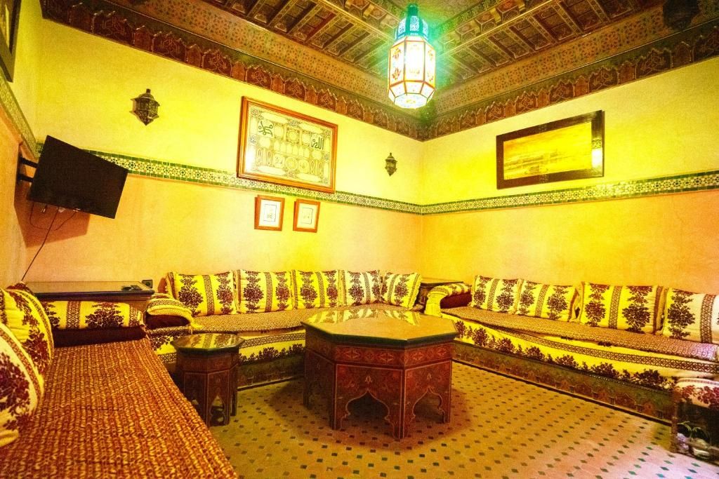 Una camera tradizionale con un divano a fantasia, un tavolino da caffè al centro e una lanterna decorativa.