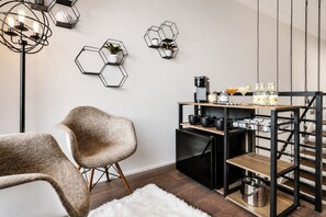 Une cuisine moderne avec un réfrigérateur noir, des étagères en bois et des décorations murales hexagonales.