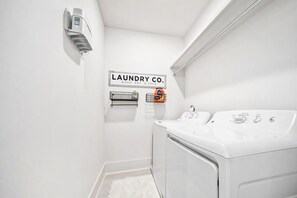 A laundry room with a wall-mounted sign reading 'LAUNDRY CO. WASH. DRY. & FOLD.' - East Nashville game room house sleeps 12, across from Hattie B's (Nashville)