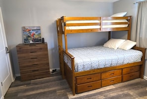 A bunk bed with a lower bunk, a wooden dresser with multiple drawers, and a painting on the dresser. - Chateau La Mer II #104 2-Bd 2-Bth 2nd Floor Close to Beach (Destin)
