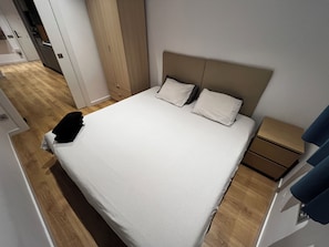 Une chambre d’hôtel avec un grand lit, deux tables de chevet et un plancher en bois.