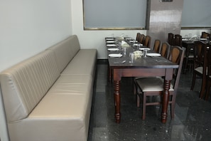 Un comedor con una mesa larga dispuesta para una comida, rodeada de sillas.