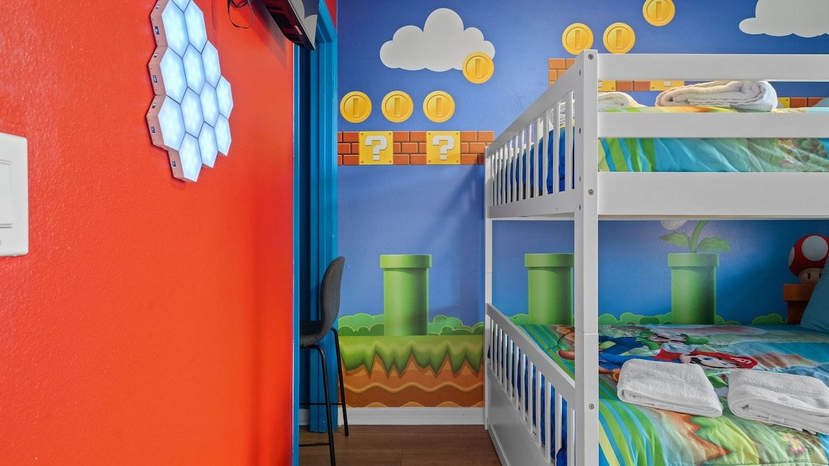 A bunk bed room with a blue wall, a white ceiling, and a door.