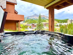 A hot tub with a mountain view, wooden architecture, and a clear sky. - NEW LISTING! Cozy Big Sky Luxury Escape- Ski In/Ski Out -Private outdoor hot tub (Big Sky)