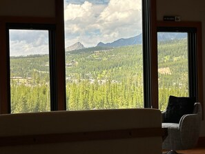 Ein Zimmer mit Blick auf eine bewaldete Landschaft und Berge.