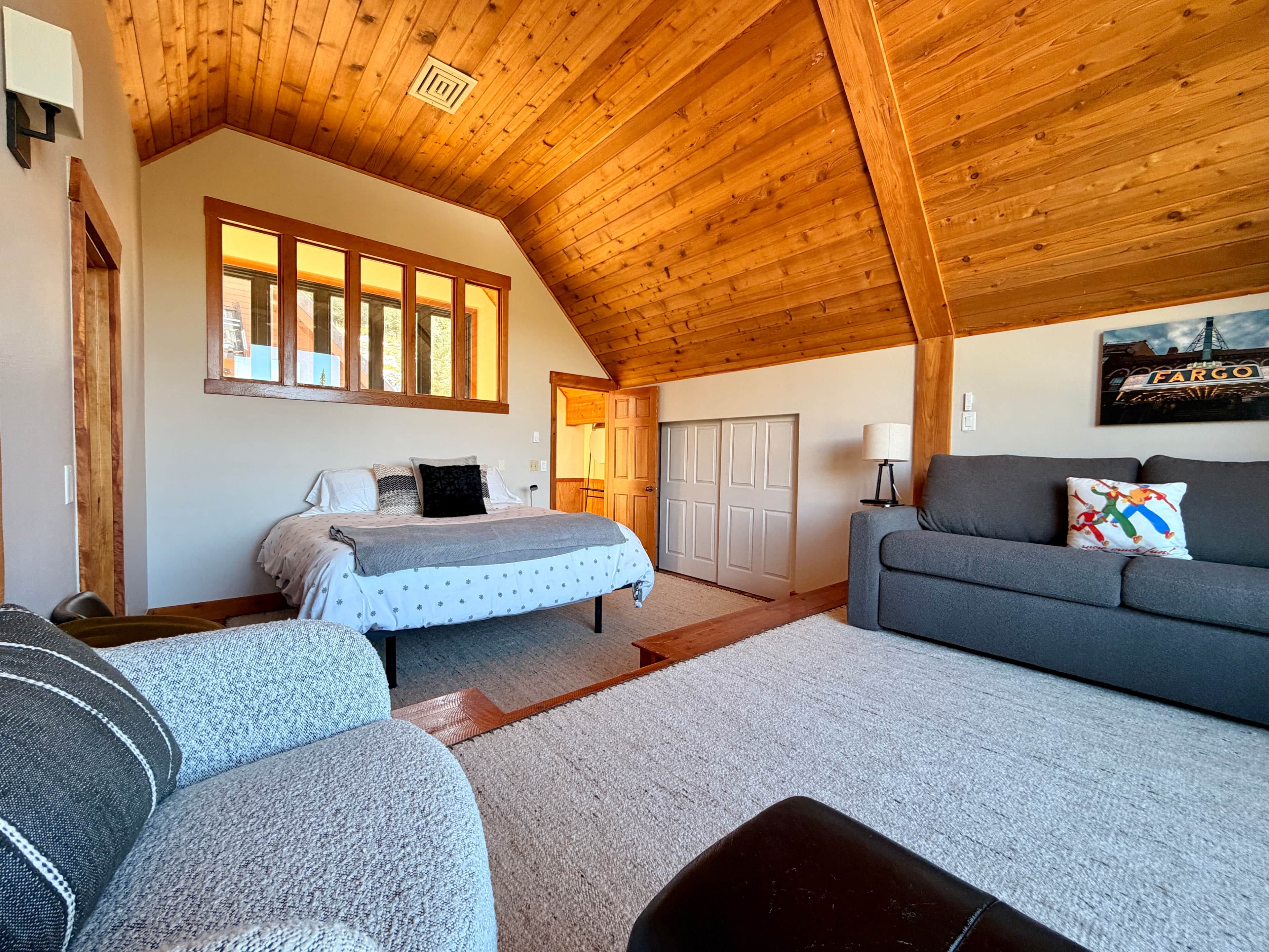 Ein Zimmer mit einem Bett, einem Sofa, einer Lampe und einem Bild an der Wand.