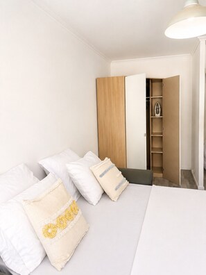 A bedroom with a bed, pillows, a wardrobe, and a closet. - Bright studio with balcony near tram (Nice)