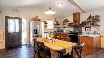 Una cocina moderna con armarios de madera, una isla central y un comedor con sillas de madera.