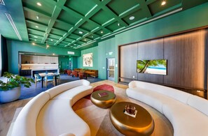 A modern lobby with a curved white sofa, a coffee table, and a reception desk. - The Crosby Hotel World Center (Miami)