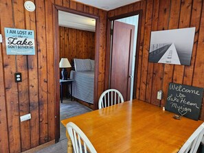 Un interno in legno con un letto, un tavolo e un cartello con su scritto 'SONO PERSO AL lago NON DISTURBARMI'.