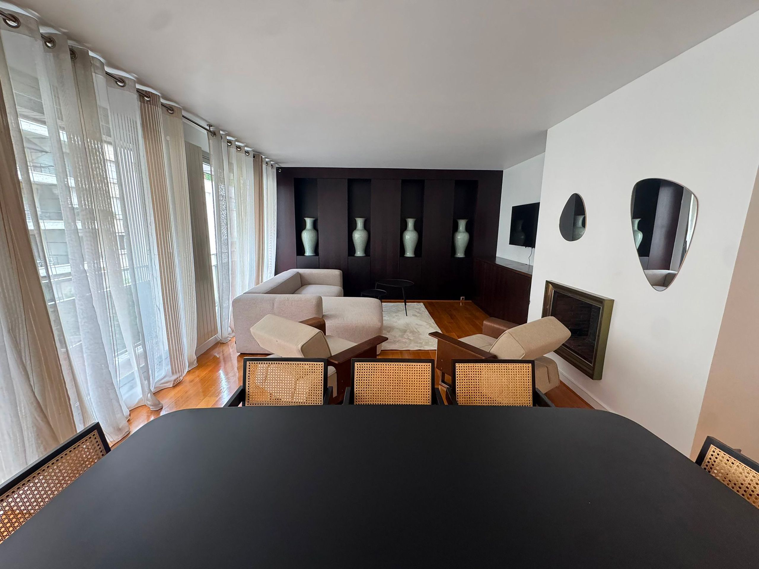 Une chambre d’hôtel moderne dotée d’un grand lit, d’une table à manger et d’un coin salon avec des fauteuils.