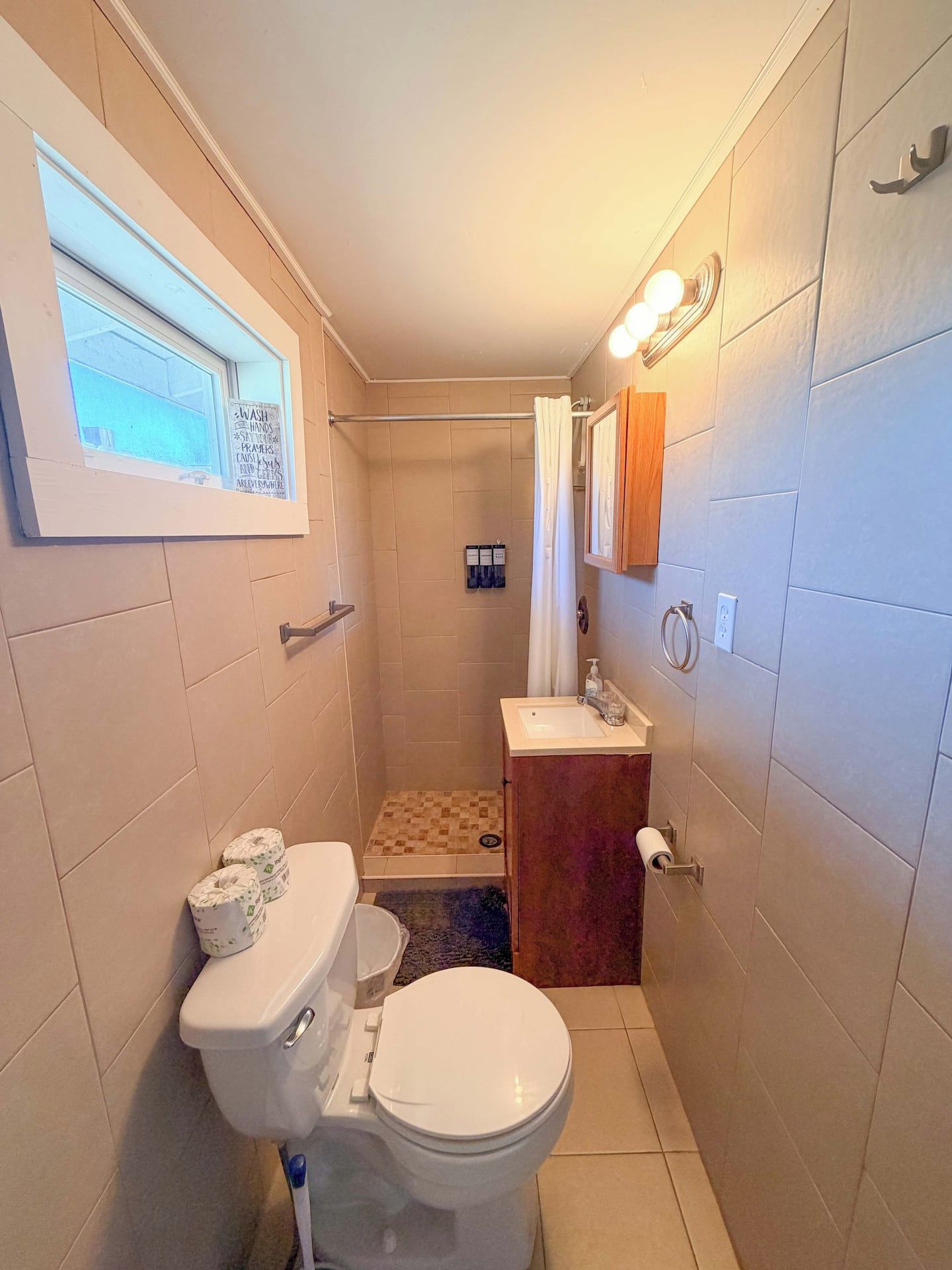 A compact bathroom with a toilet, sink, and shower area.