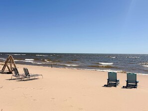 Een strand met twee rijen strandstoelen en een wachthok.