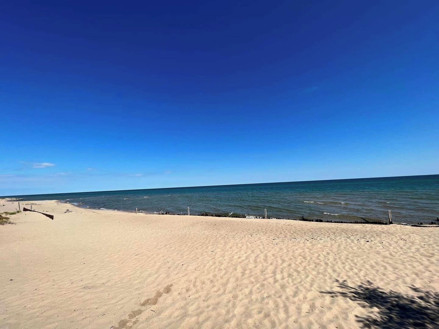 Ein Strand mit blauem Himmel und ruhiger See.