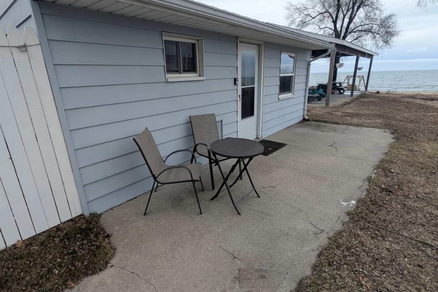 A house with a patio area featuring two chairs and a table.