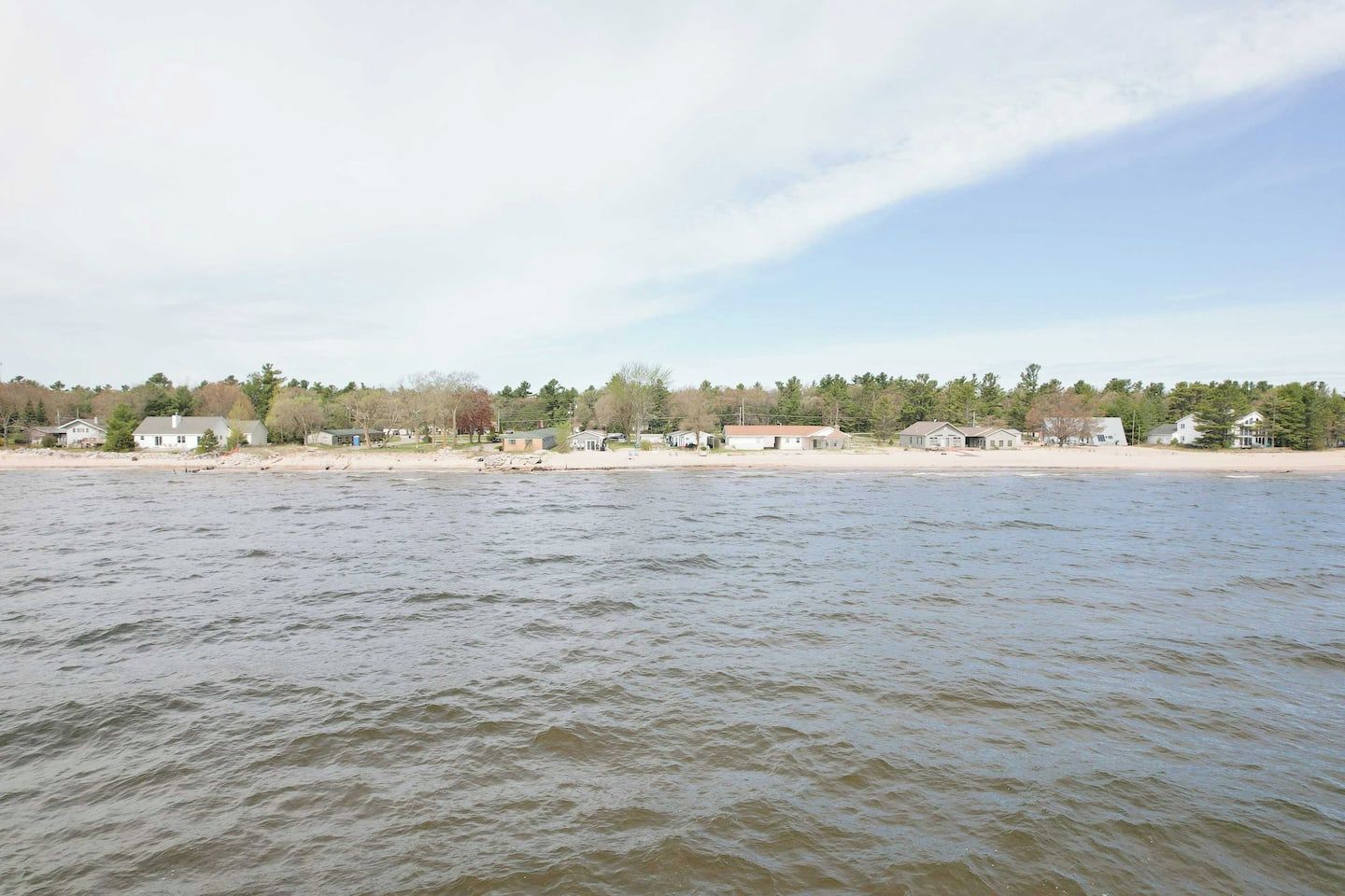 A waterfront property with a sandy beach and a row of houses.