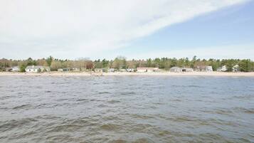 A waterfront property with a sandy beach and a row of houses.