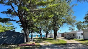 Un camping con vehículos recreativos y casas móviles, un camino pavimentado y un cielo despejado.