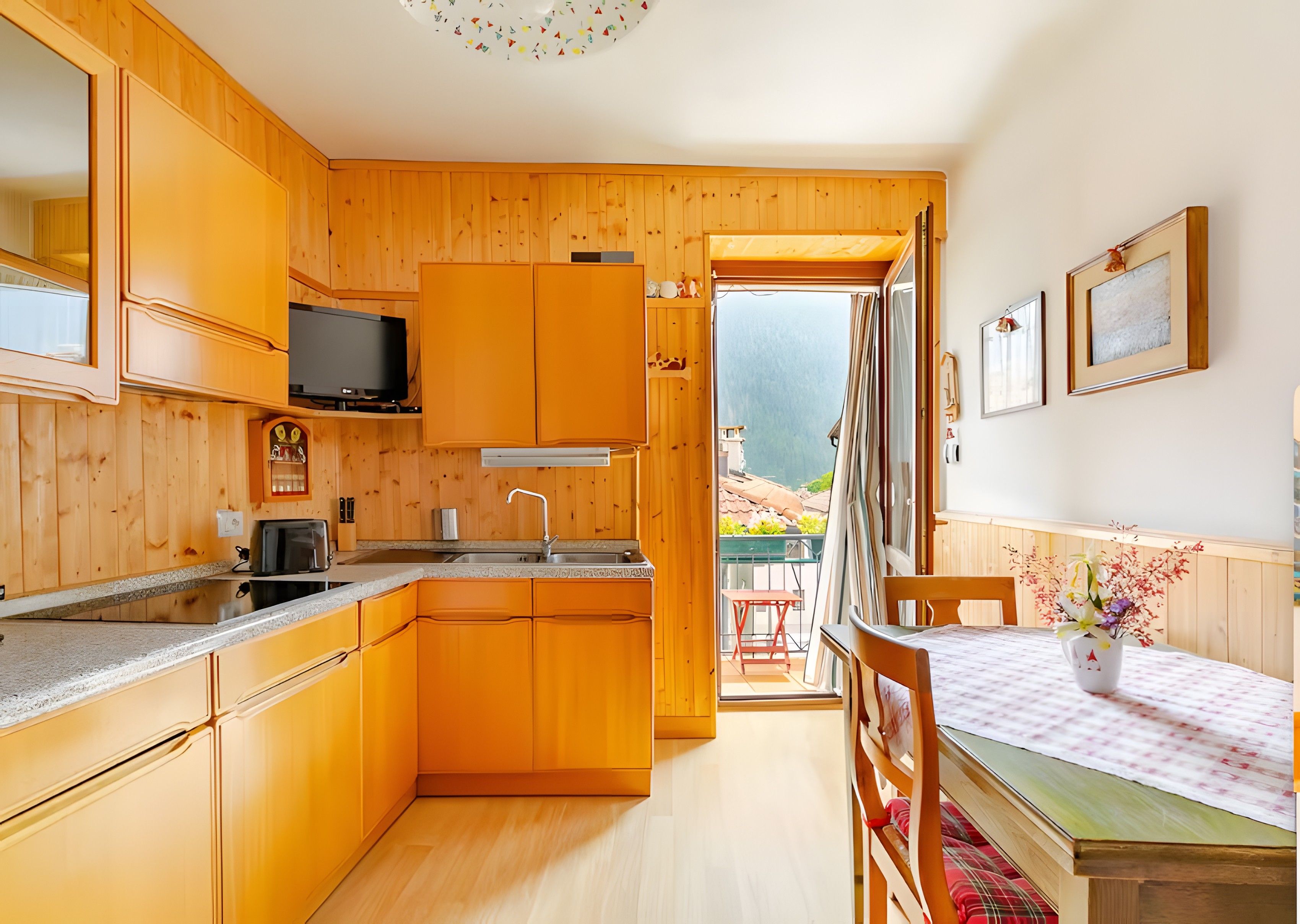 Un intérieur en bois comprenant une cuisine, un coin repas et un balcon avec vue.