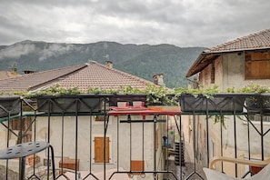 A balcony with a view of traditional buildings and mountains.